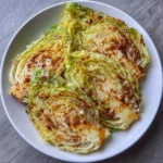 Crispy cabbage wedges in the air fryer basket with golden edges